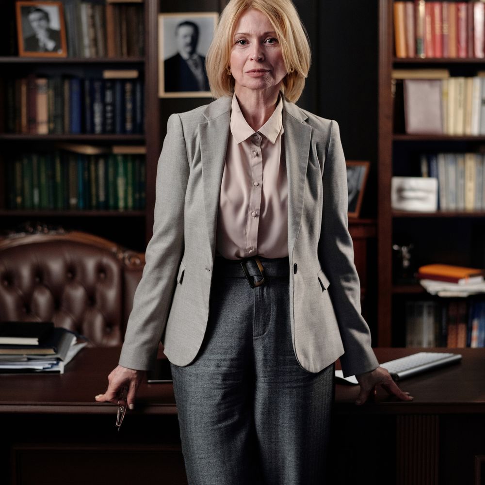 A confident professional standing in a modern office library, representing career growth